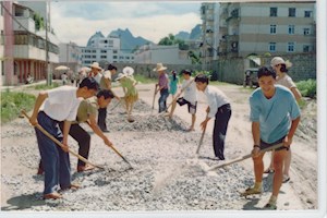 1998年7月1日，学院党员们为学院东门至人民银行路段铺路